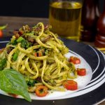 Tallrik med grön vegansk pasta med broccoli och basilika