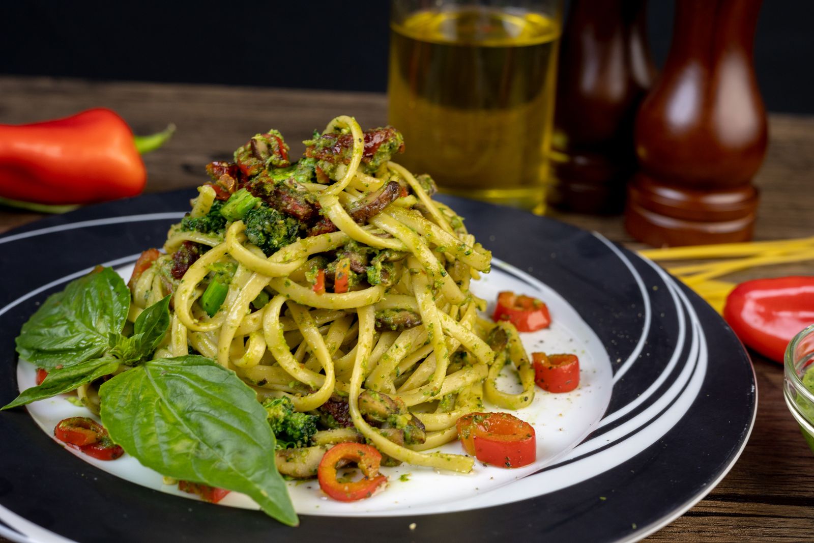 Tallrik med grön vegansk pasta med broccoli och basilika