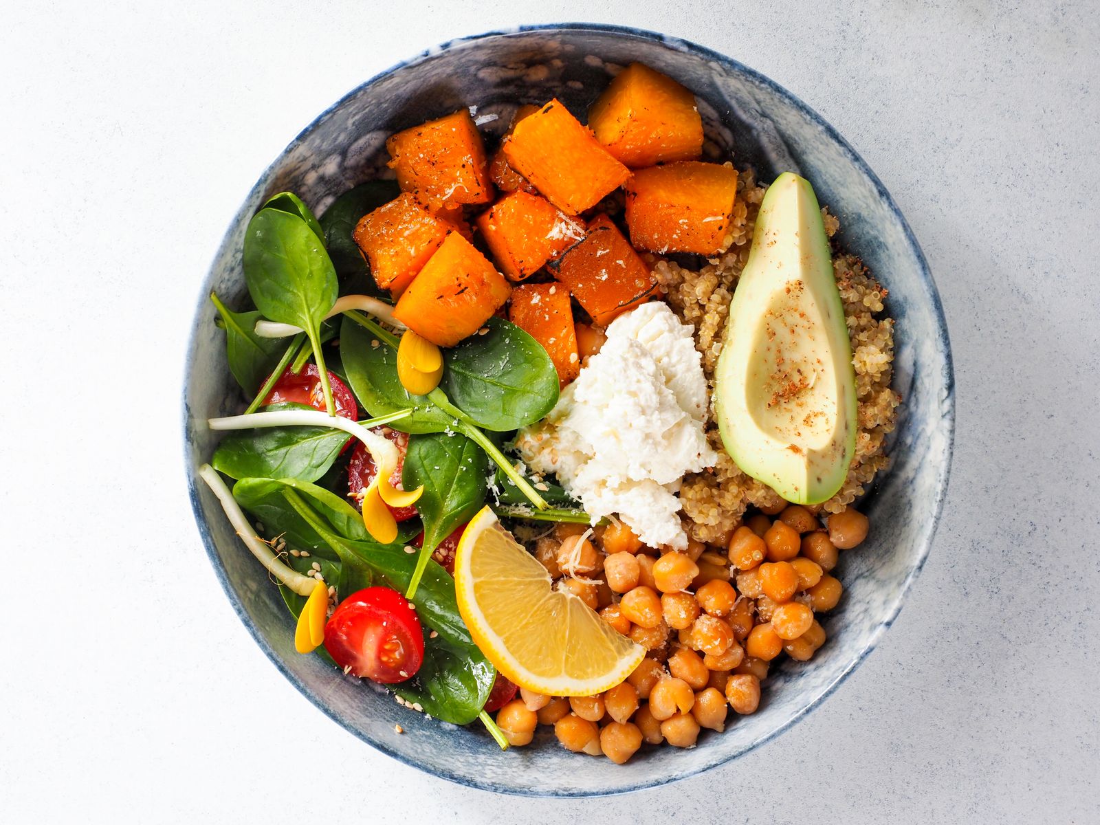 Vegansk lunchbowl med rostad sötpotatis, kikärtor, tomat och citron