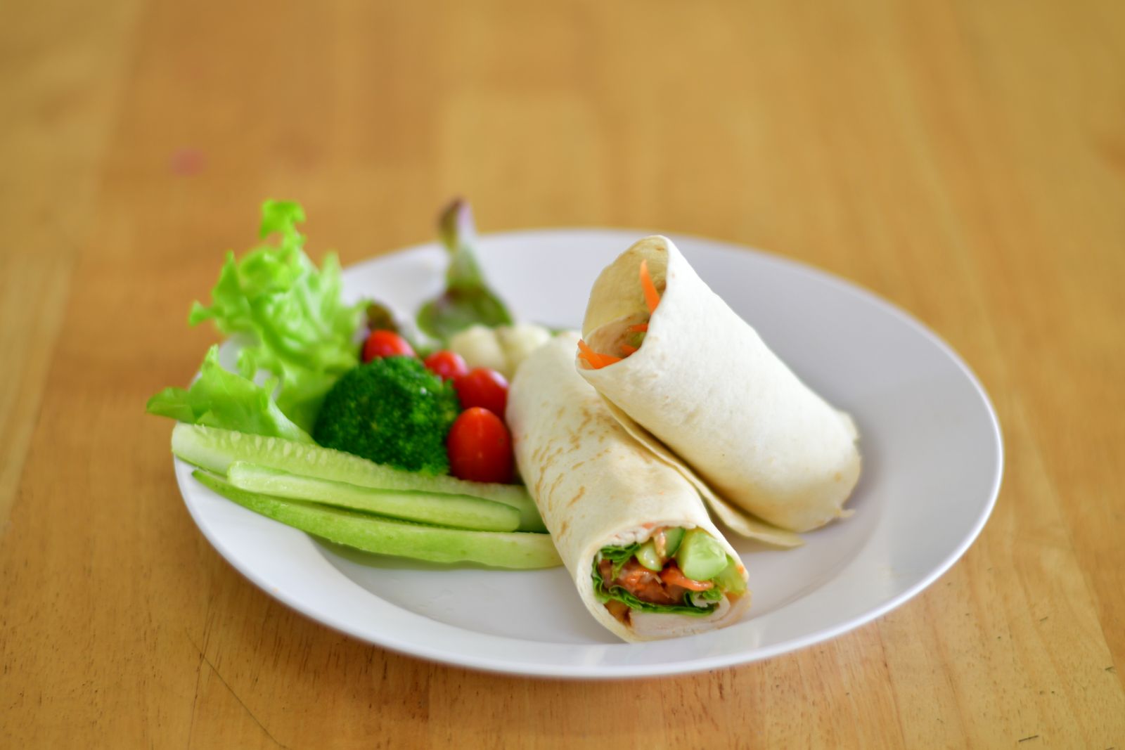 Grönsakswraps på en tallrik med sallad, broccoli och tomater