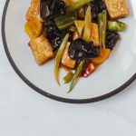 Vegansk tofuwok med paprika och svamp på en tallrik