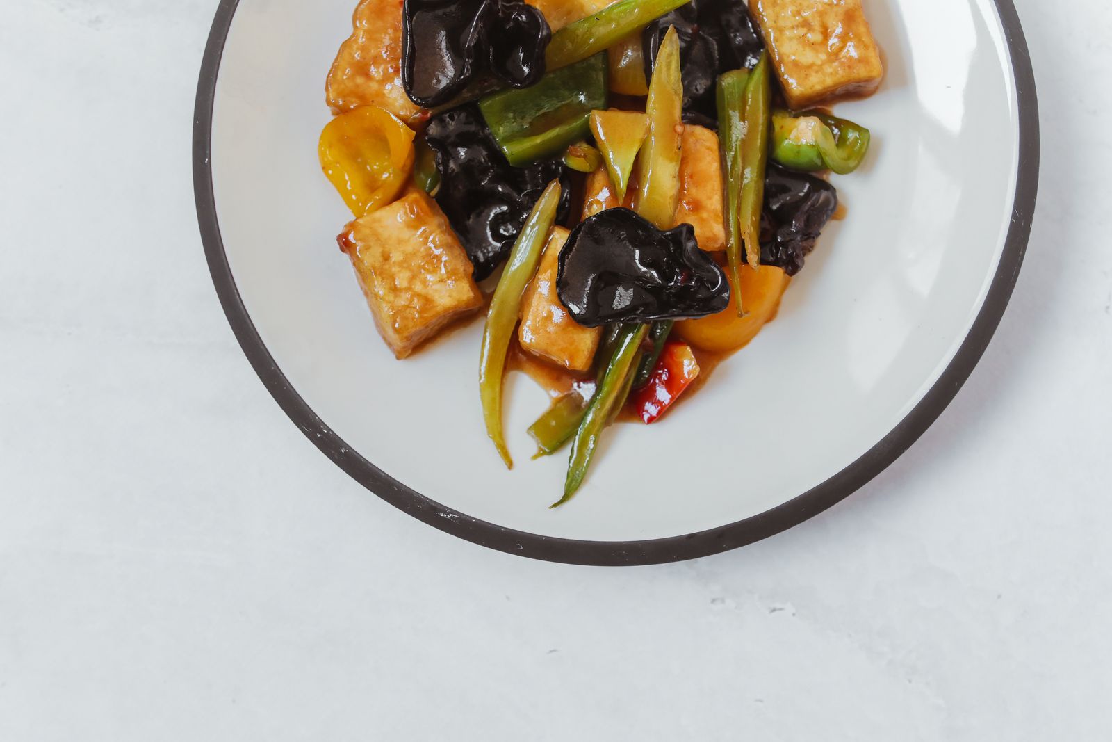 Vegansk tofuwok med paprika och svamp på en tallrik