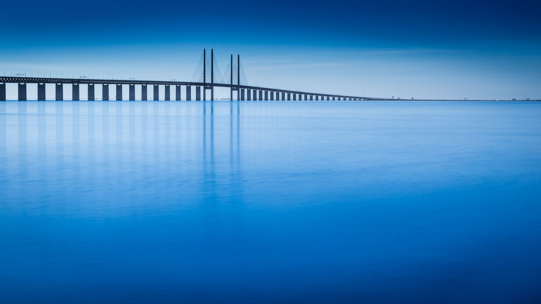 Öresundsbron sträcker sig över sundet mellan Sverige och Danmark i blått morgonljus