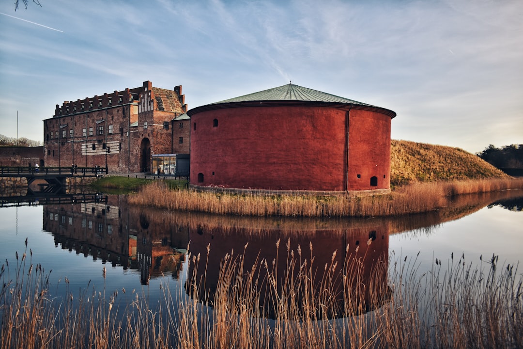 Malmöhus slott med sitt runda rödputsade kanontorn speglat i vallgraven
