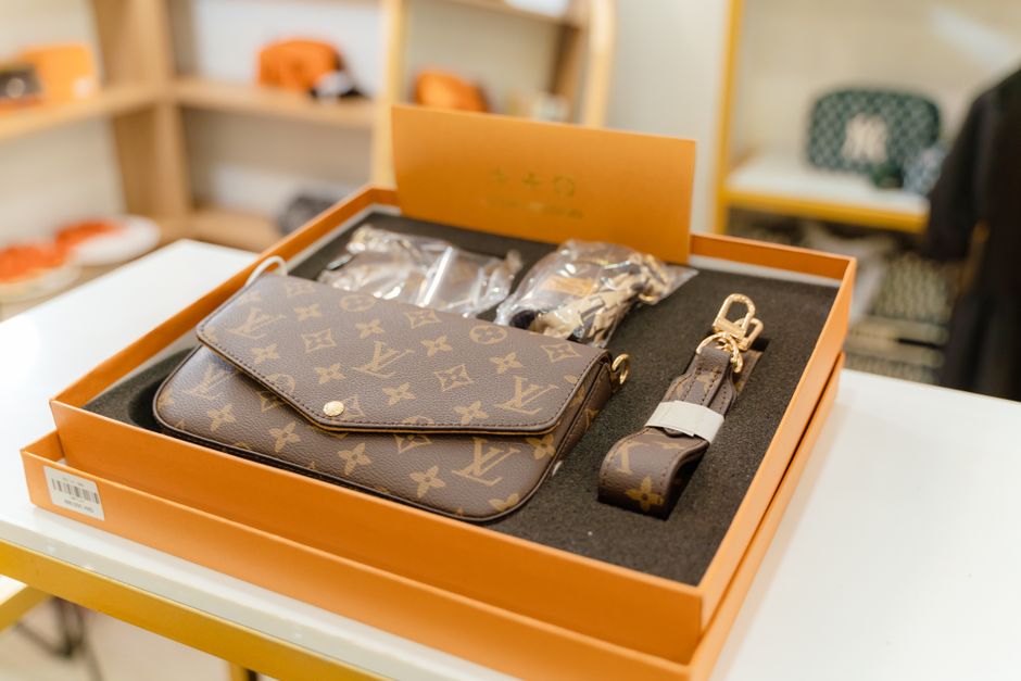 Louis Vuitton Félicie i Monogramkanvas liggande i sin orange originalkartong med dammpåse