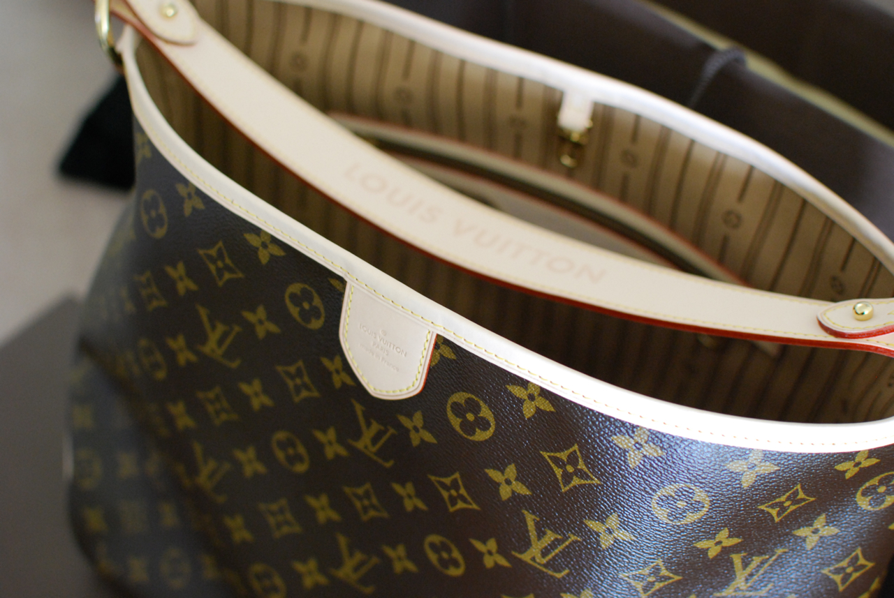 Närbild på den präglade texten LOUIS VUITTON och hetstämpeln på en äkta Neverfull i Monogramkanvas