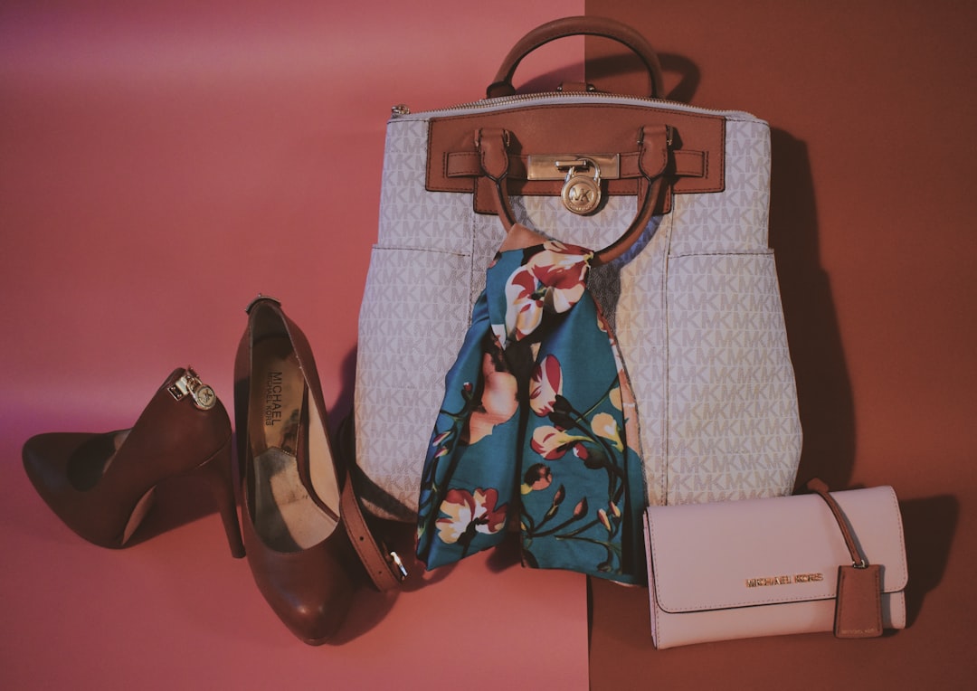Michael Kors Hamilton-väska i ljus signaturkanvas med hänglås, tillsammans med en vit axelremsväska och bruna klackskor