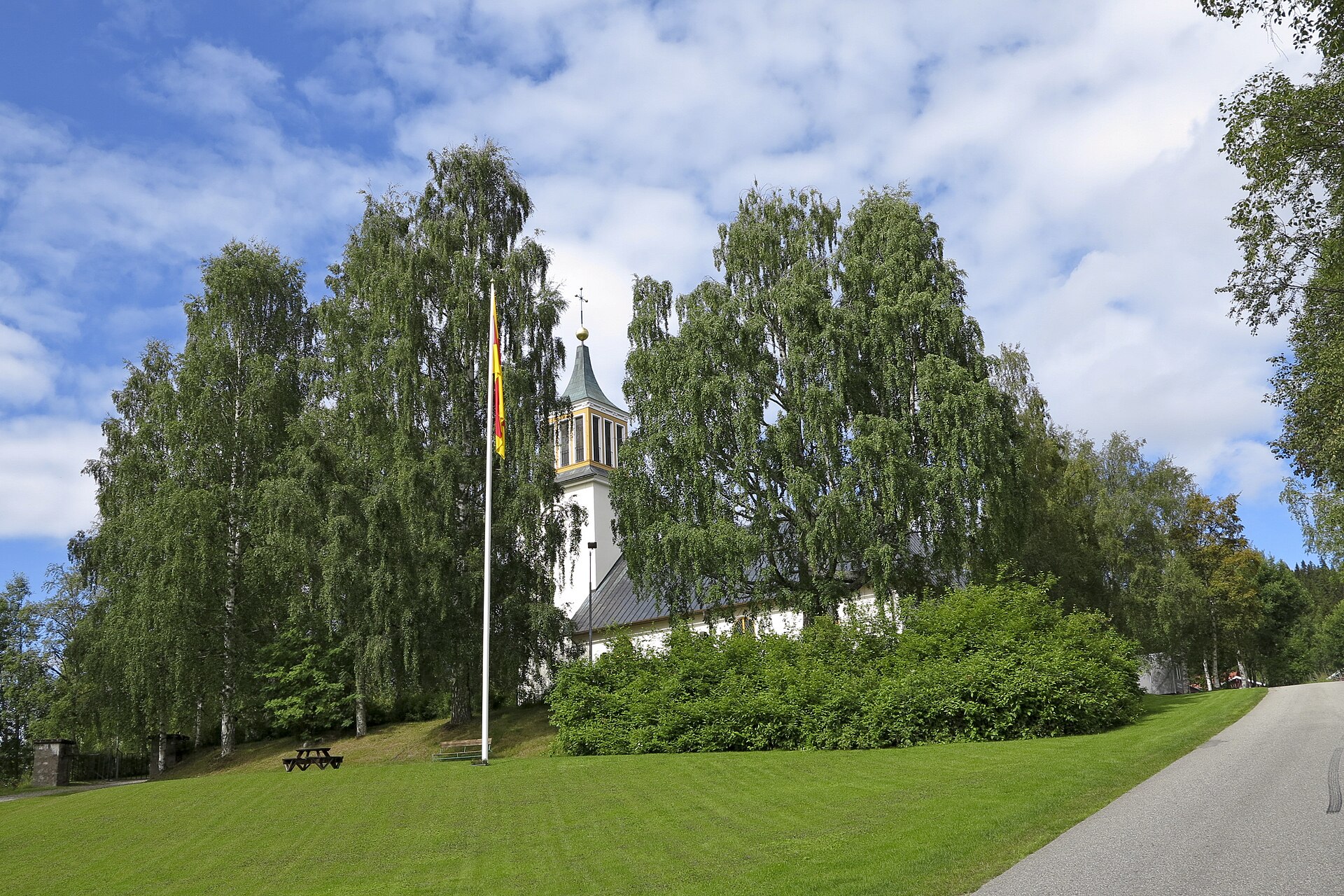 Dorotea kyrka bakom björkar en sommardag