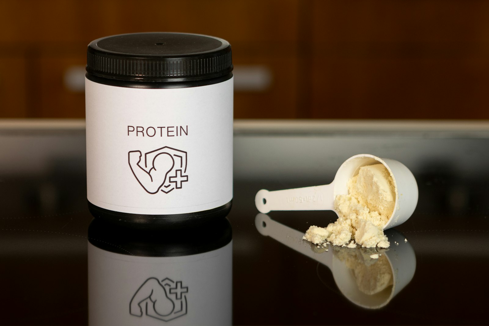 Burk med proteinpulver och ett doseringsmått med pulver bredvid