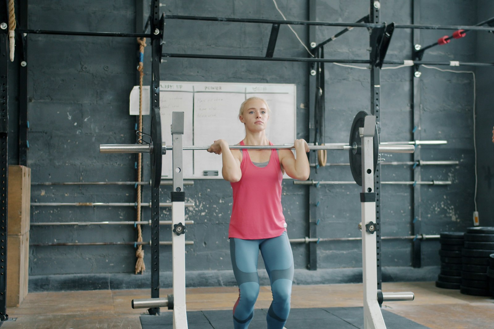 Kvinna som tränar med skivstång i ett gym