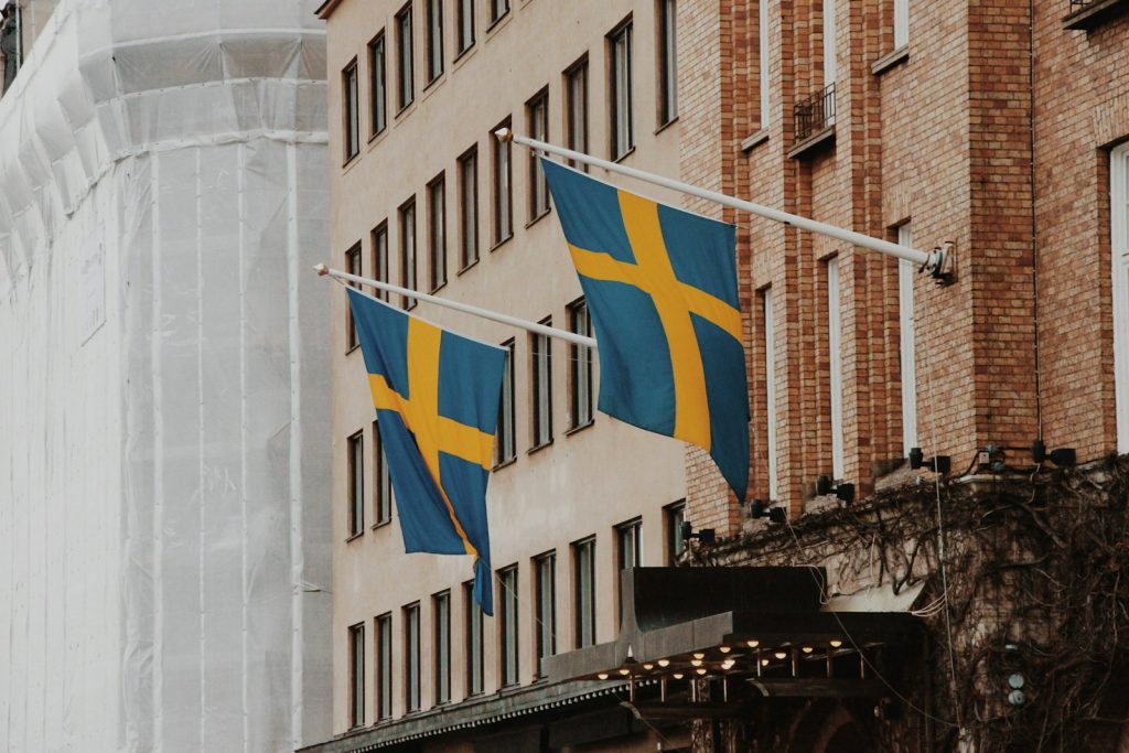 Två svenska flaggor på en byggnadsfasad