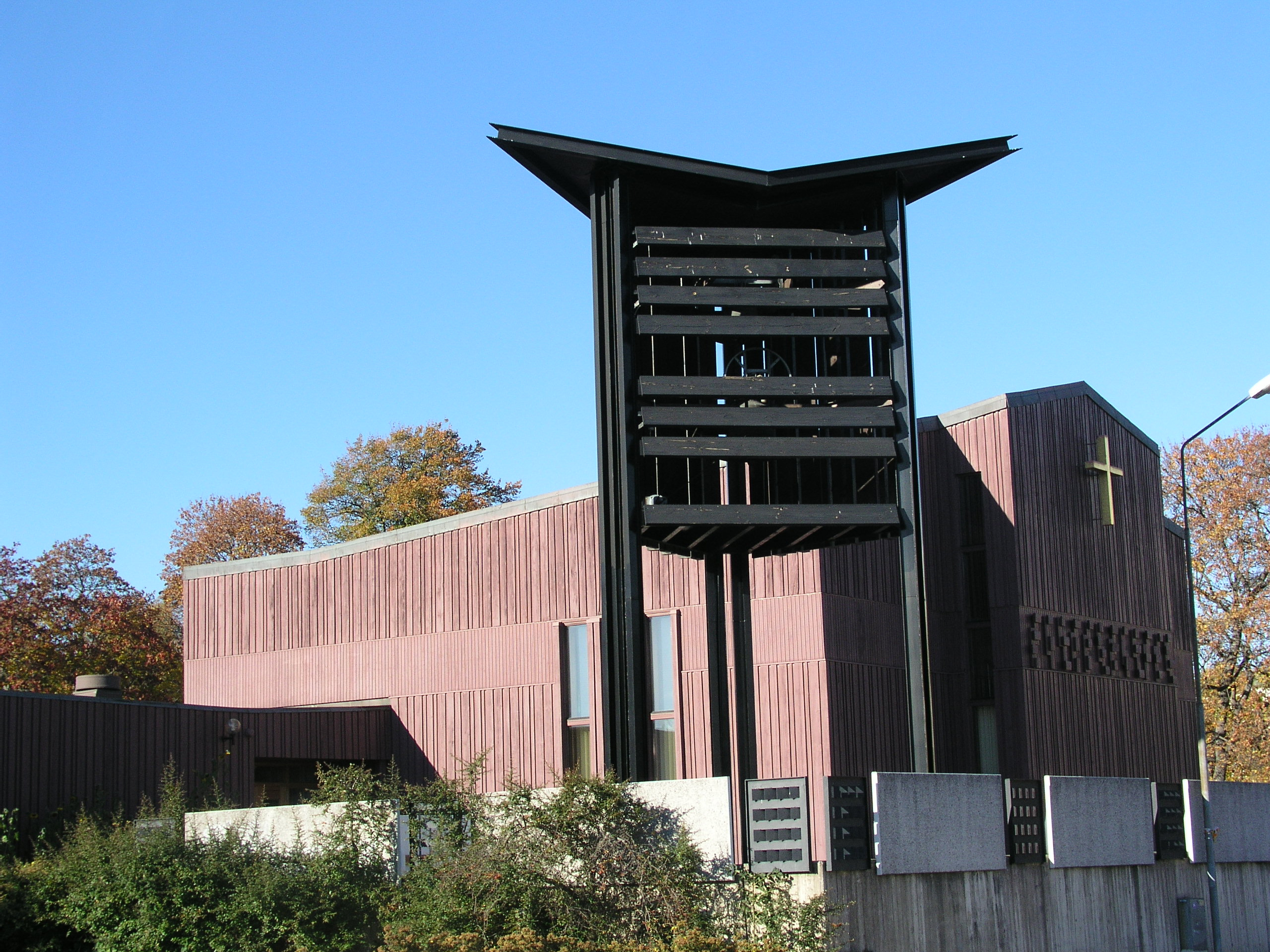 Tumba kyrka med klockstapel och förgyllt kors på fasaden