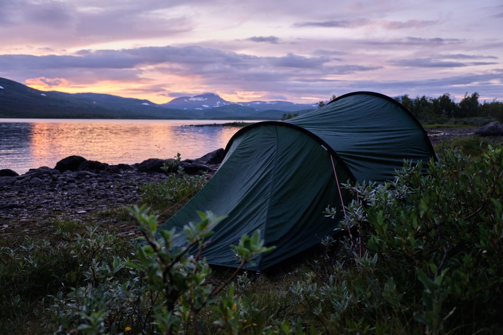 Tält vid en fjällsjö i kvällsljus. Foto: Sidde via Pexels