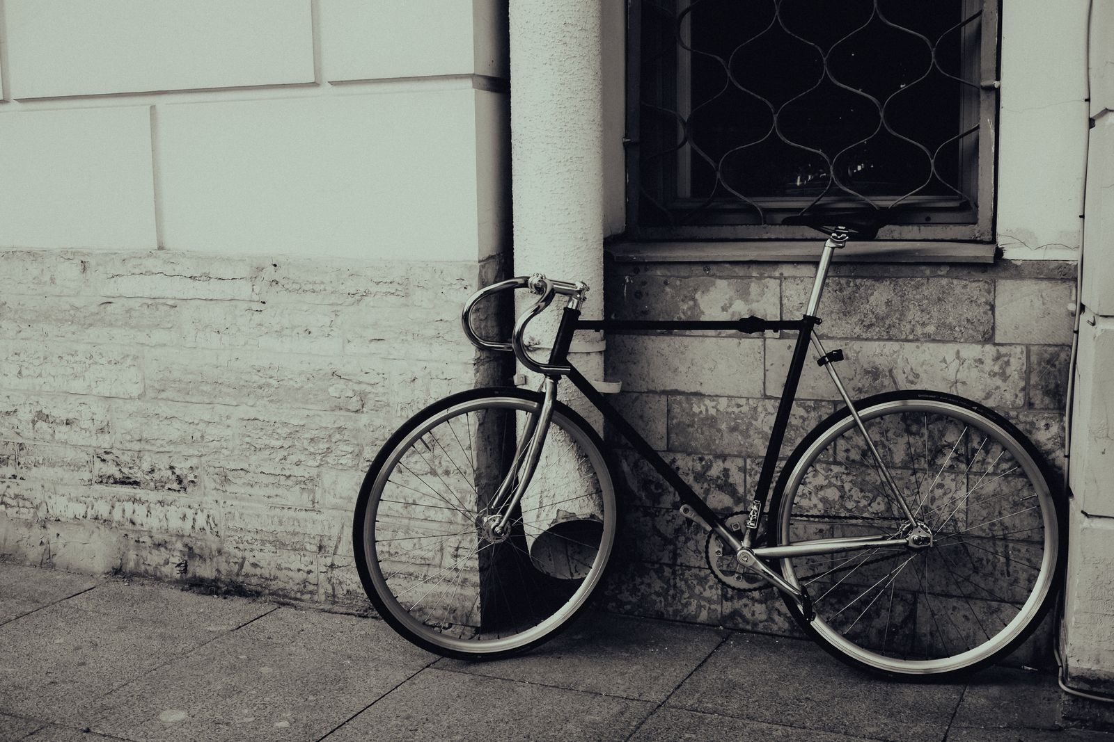Svart singlespeed-cykel lutad mot betongvägg