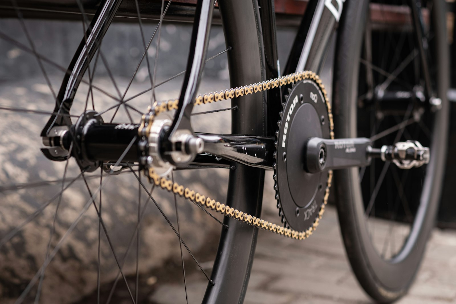 Guldfärgad kedja på en svart bancykel med bakåtriktade gaffeländar