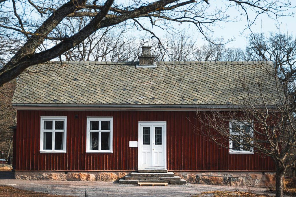 Ett rött svenskt trähus med vita knutar