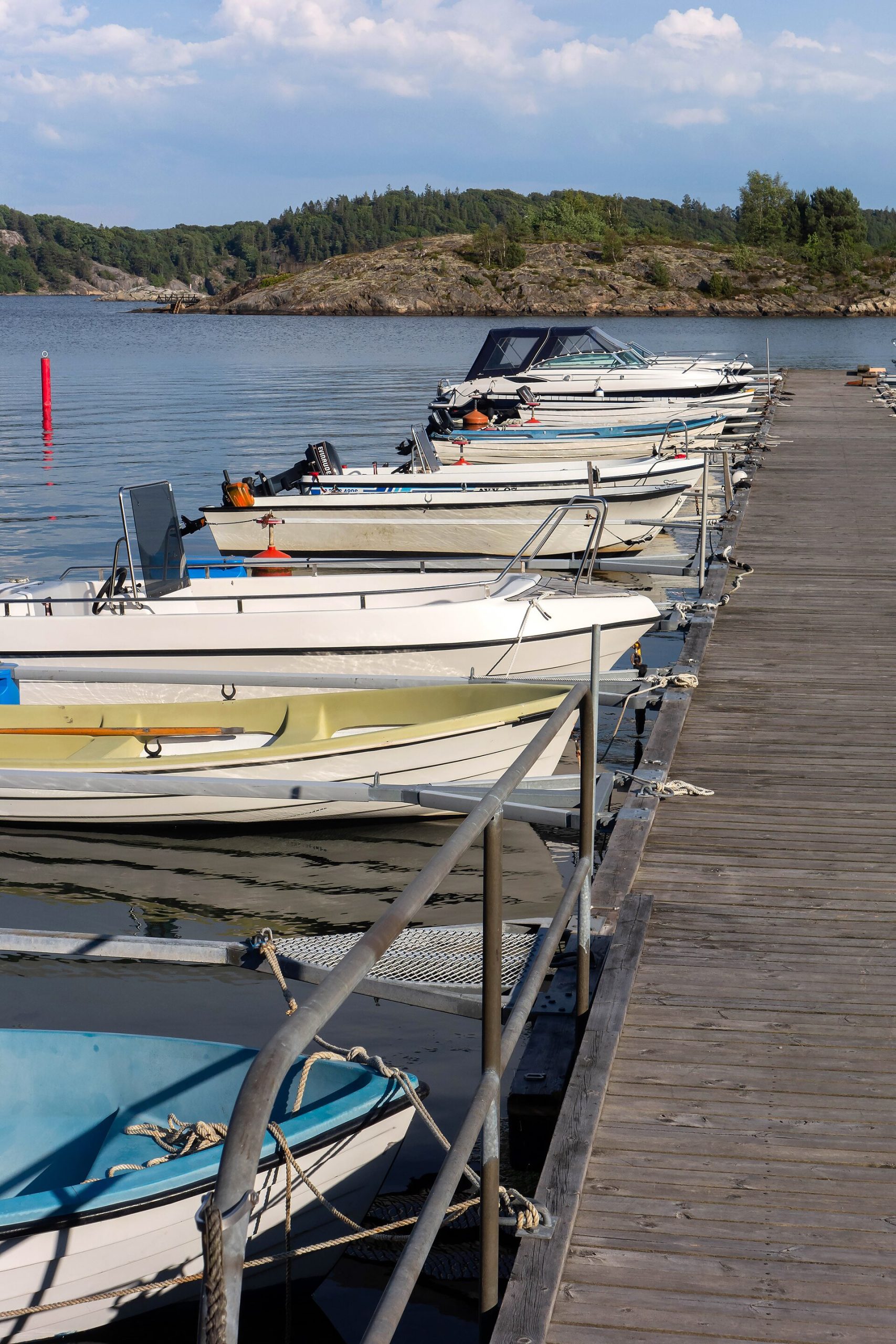 Små motorbåtar förtöjda vid en träbrygga i skärgården